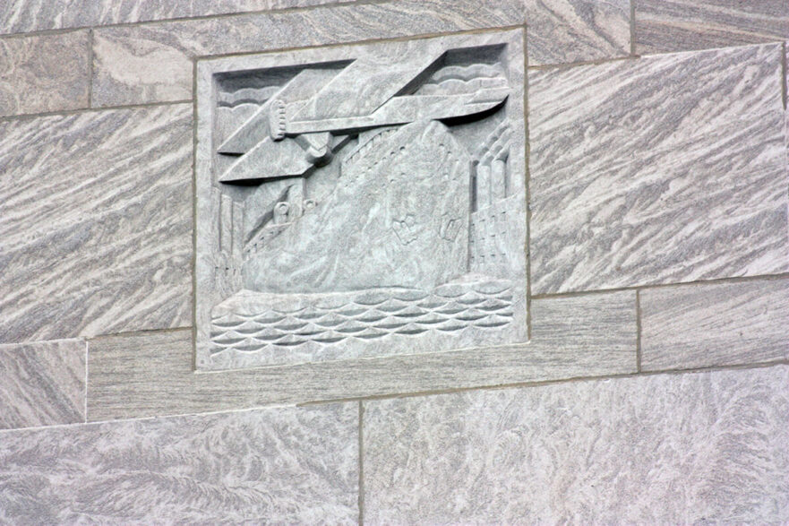 34 Carving on the upper area of the north and south extensions of City Hall, this is an Art Deco representation of a boat and plane, circa 2022.