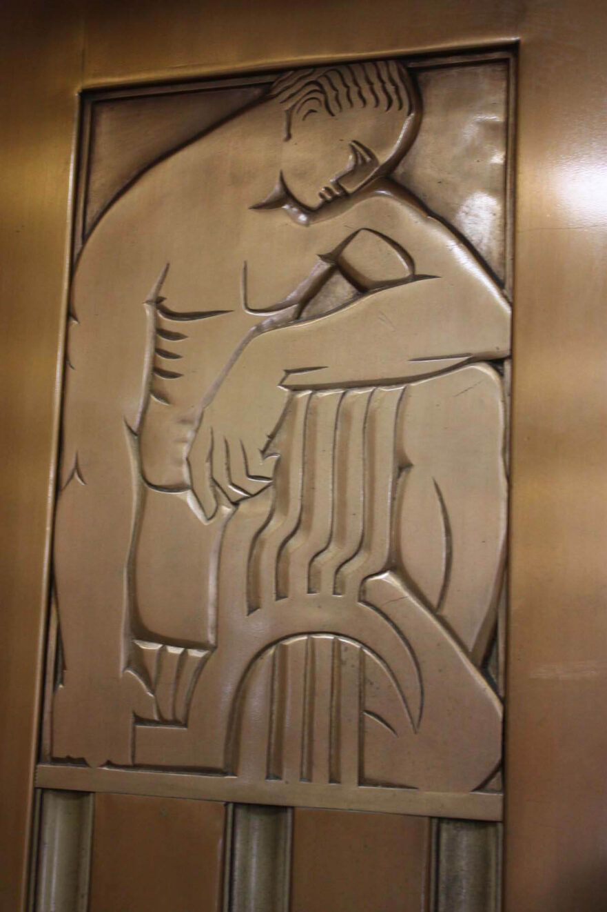 9 Close up of the figure on the left elevator door in the main lobby.